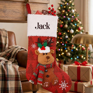 Personalized red Christmas stocking with a plush reindeer hanging from a mantel hook in a decorated living room