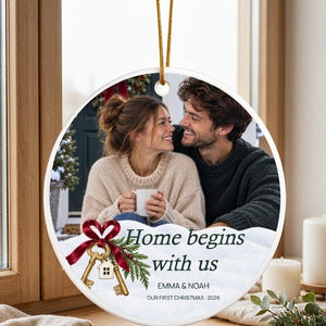 Personalized first home Christmas ornament hanging on a window catch, daylight passing through the clear acrylic body