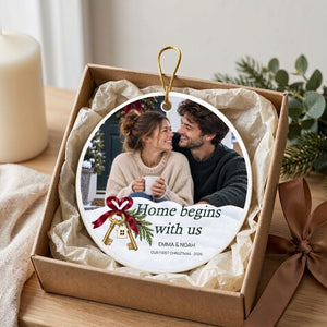Personalized first home Christmas ornament resting in an open kraft gift box lined with ivory tissue paper