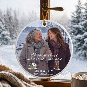Personalized long distance ornament for Mom hanging on a window catch, cold daylight passing through the clear acrylic body
