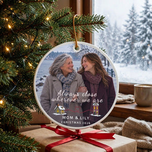 Personalized long distance ornament for Mom hanging on a decorated tree with kraft gifts tied with red ribbon at the base
